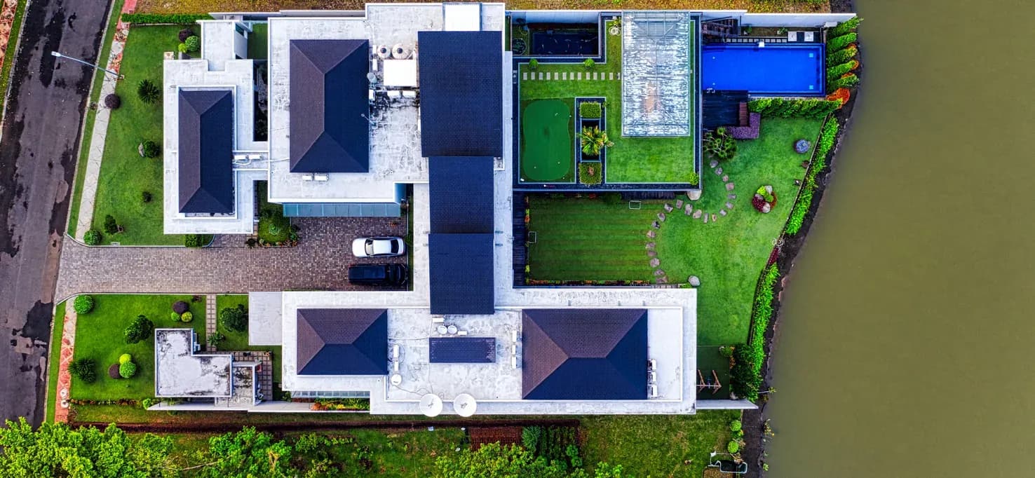 Aerial view of a property with gardens beside a river