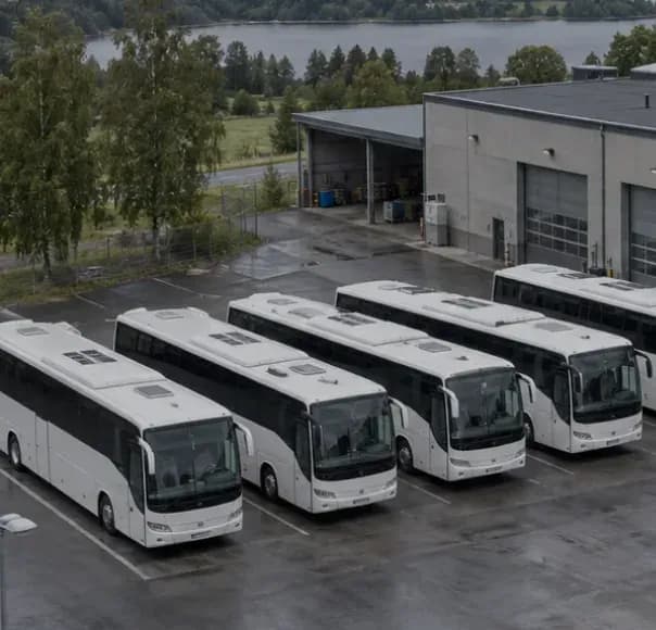 White coaches parked in a row outside a bus depot